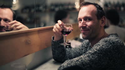 stock-footage-young-happy-man-in-cafe-raising-toast-with-glass-of-wine-to-camera